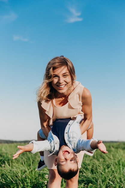 Mulher feliz com criança brincando juntos no campo