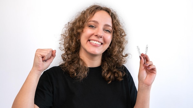 Foto mulher feliz com dentes retos e saudáveis de sorriso branco usando aparelho removível transparente