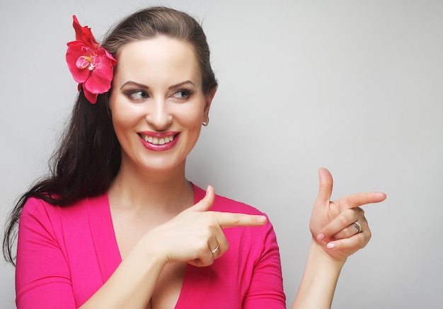 Mulher feliz com flor rosa no cabelo