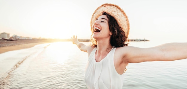 Mulher feliz com os braços estendidos desfrutando de liberdade na praia