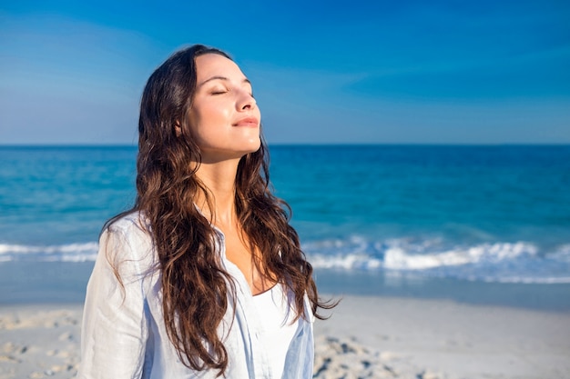 Mulher feliz com os olhos fechados na praia