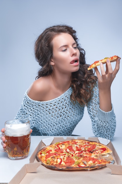 Mulher feliz com pizza e cerveja no espaço cinza, espaço para texto