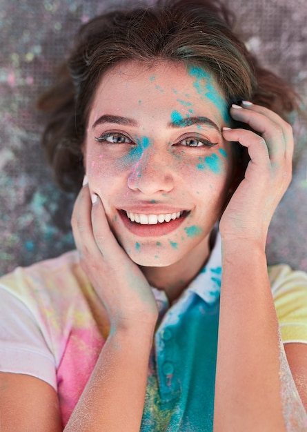 Mulher feliz com pó de Holi no rosto