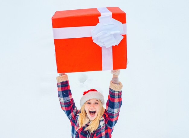 Mulher feliz com presente ou caixa de presente ao ar livre. Feliz inverno. Presente feminino caixa de presente vermelha com