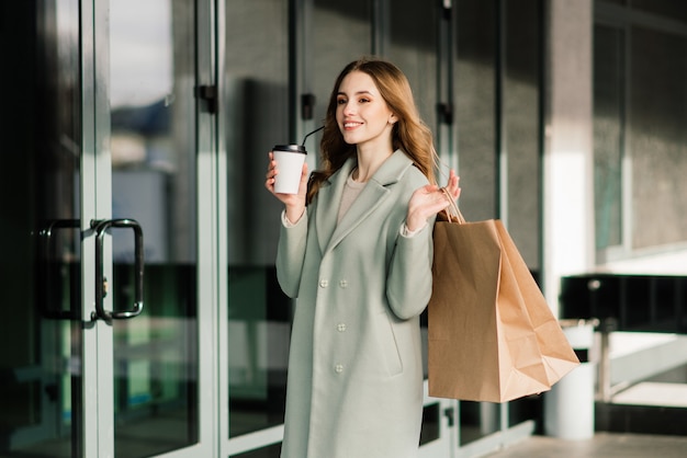 Mulher feliz com sacolas de compras, curtindo as compras. Consumismo, conceito de estilo de vida