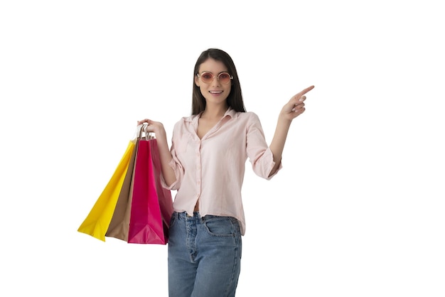 Mulher feliz com sacolas de compras na mão indica algo