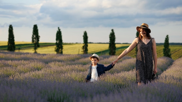 Mulher feliz com seu filho no campo de flores de lavanda