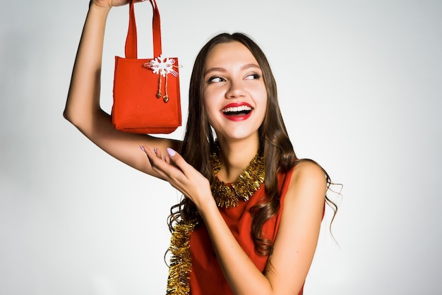 Mulher feliz com um vestido vermelho segurando uma pequena bolsa