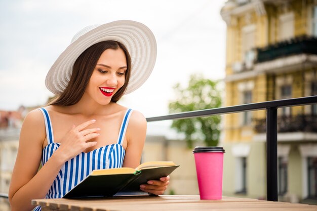 Mulher feliz com vestido de verão posando com chapéu de palha