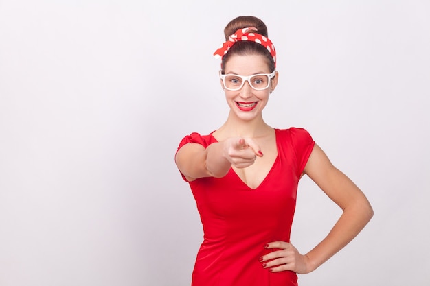 Foto mulher feliz com vestido vermelho apontando o dedo e um sorriso dentuço