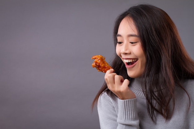 Mulher feliz comendo frango frito