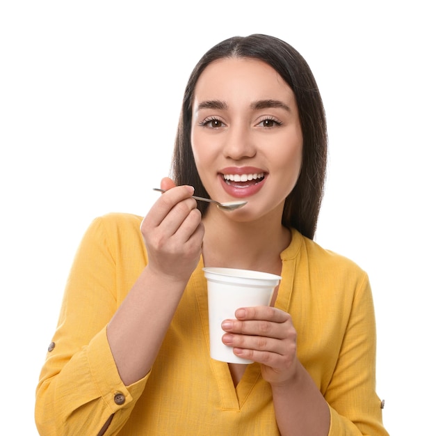 Mulher feliz comendo iogurte saboroso no fundo branco