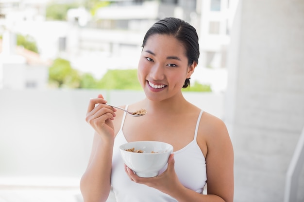 Mulher feliz comendo tigela de cereal