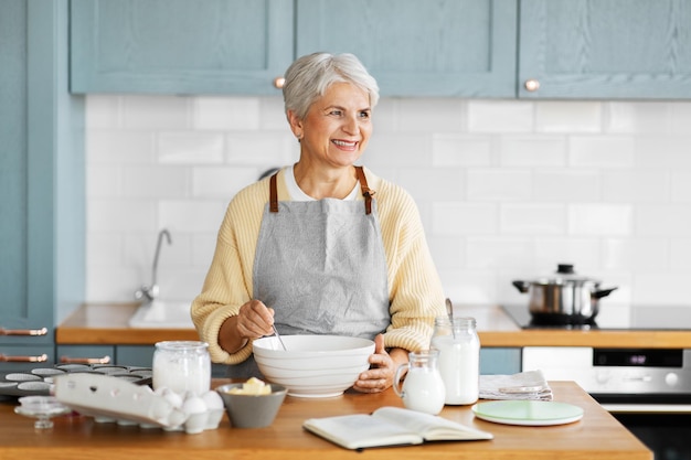 mulher feliz cozinhando comida na cozinha em casa