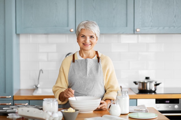 mulher feliz cozinhando comida na cozinha em casa