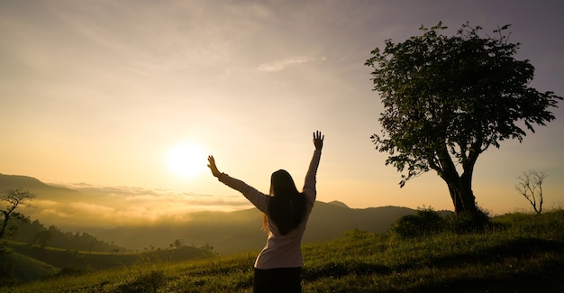 Mulher feliz curtindo a vida ao nascer do sol nas montanhas