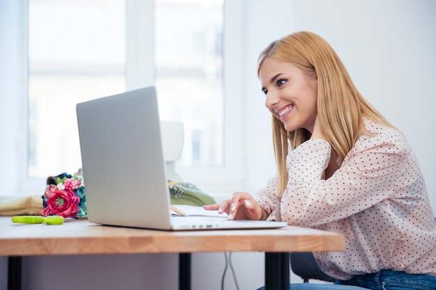 Mulher feliz deisgner usando laptop