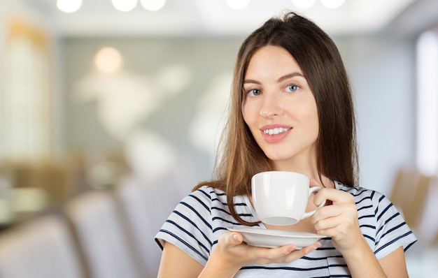 Mulher feliz, desfrutando de uma xícara quente de chá