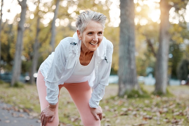 Mulher feliz e idosa cansada correndo no parque natural ao ar livre para aposentadoria saúde bem-estar e treino de fitness Caminho de exercícios de saúde e corredor com treinamento de fadiga para corrida de maratona de idosos