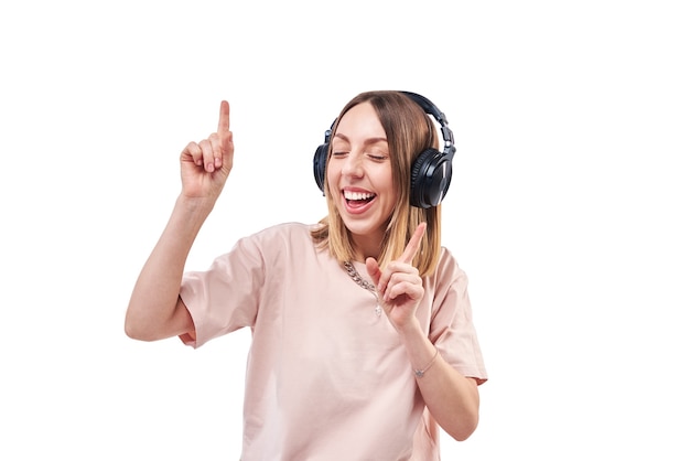 Mulher feliz e sorridente com fones de ouvido, ouvindo música e dançando