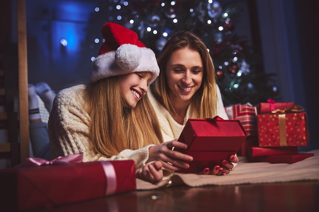 Mulher feliz e sua filha recebendo presentes do Papai Noel