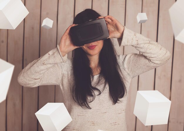 Foto mulher feliz em óculos vr com objetos 3d ao redor