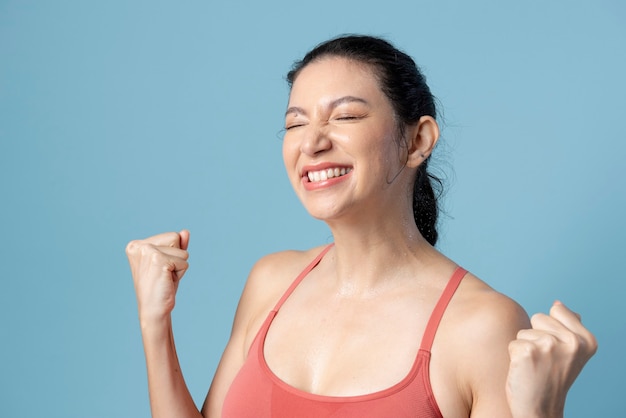 Mulher feliz em roupas esportivas em fundo azul