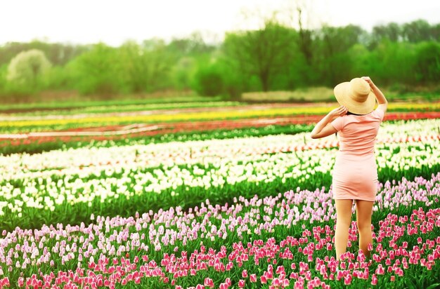 Mulher feliz em um campo florido de tulipas