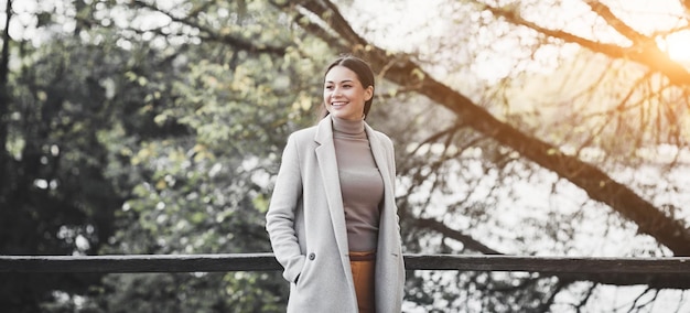 Mulher feliz em um casaco ao ar livre