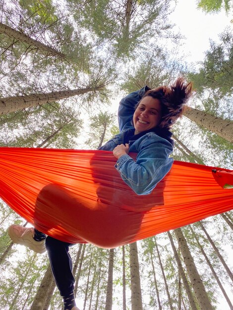 Mulher feliz em uma hamaca na floresta