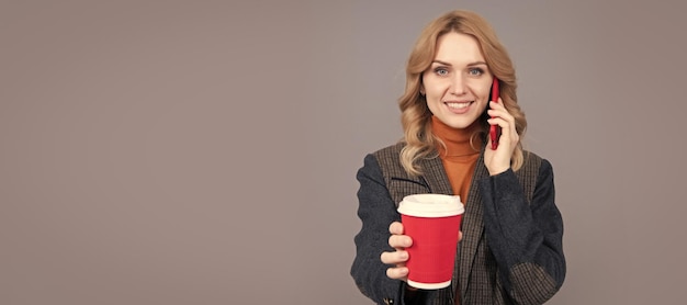 Mulher feliz fala no celular dando chá de fundo cinza de xícara quente Cabeçalho isolado de retrato de mulher