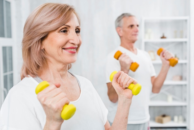 Mulher feliz, fazendo, exercício, com, dumbbells