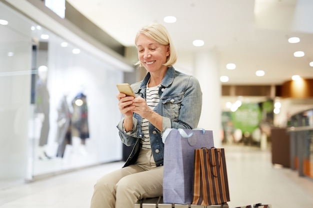 Mulher feliz fazendo post sobre compras nas mídias sociais