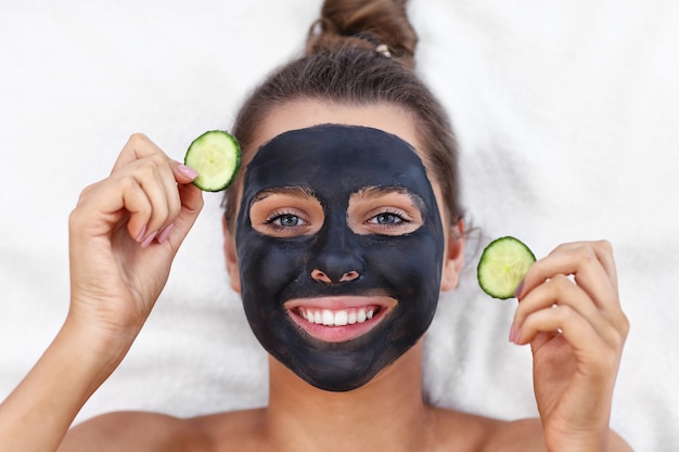 mulher feliz fazendo tratamento facial no salão spa