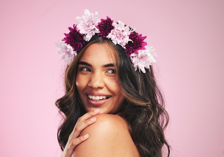 Foto mulher feliz flores e pensando com coroa em estúdio para cuidados com a pele de beleza natural e plantas em fundo rosa modelo de rosto e guirlanda floral para sustentabilidade eco dermatologia e cosméticos capilares