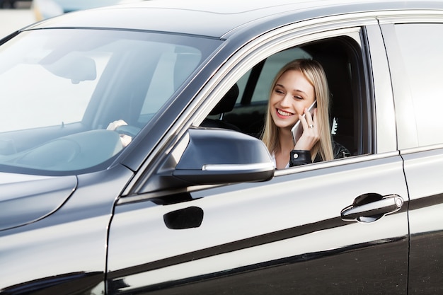 Mulher feliz gosta de comprar carro novo e moderno e chama um amigo