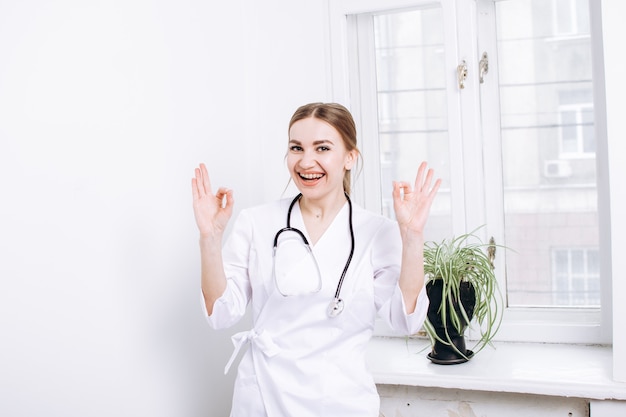 Mulher feliz, médica, com um jaleco branco e um estetoscópio