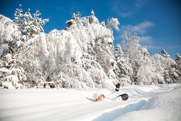 Mulher feliz na floresta de neve de inverno