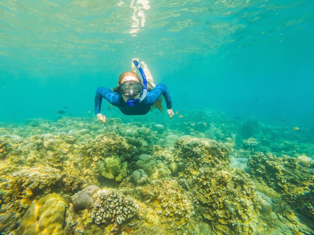 Mulher feliz na máscara de mergulho mergulha debaixo d'água com peixes tropicais na piscina do mar de recifes de corais Viagem estilo de vida esporte aquático aventura ao ar livre aulas de natação nas férias de verão na praia