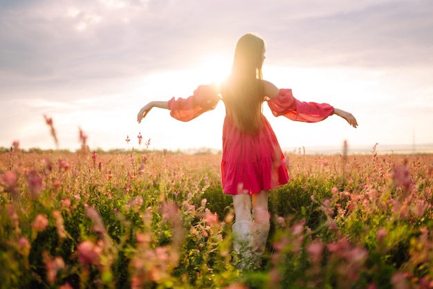 Mulher feliz no campo florescente Férias na natureza relaxam e estilo de vida Paisagem de verão