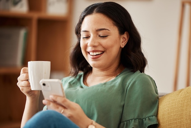 Mulher feliz no sofá com telefone café e relaxar lendo e-mail ou mídia social meme na sala de estar rede de telefone celular e felicidade menina em casa com sorriso chat e pesquisa na internet para post