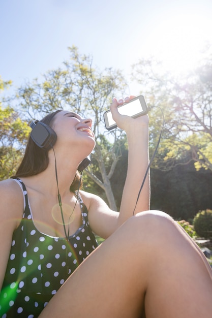 Foto mulher feliz ouvindo música no celular