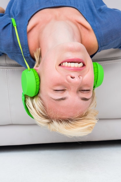 Mulher feliz ouvindo música no sofá