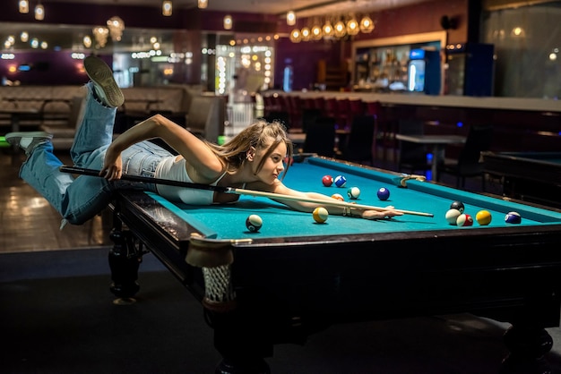 Mulher feliz passa o tempo livre no pub jogando sinuca