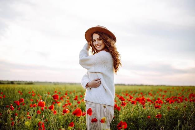 Mulher feliz posando em um campo de papoulas