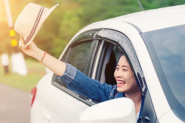 Mulher feliz relaxada nas férias viagem de verão roadtrip olhando a natureza vista fora da janela do carro