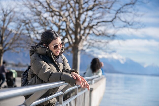 Mulher feliz relaxando em um dia ensolarado à beira do lago Genebra Suíça