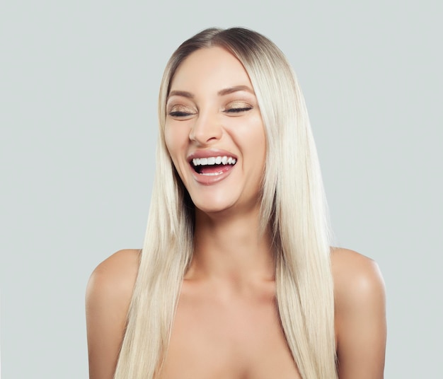 Mulher feliz rindo modelo feminino com cabelo loiro longo e saudável em fundo branco Expressões faciais expressivas