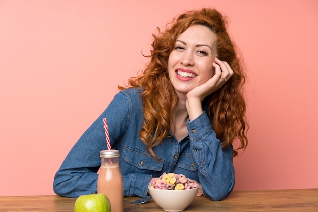 Mulher feliz ruiva tomando café da manhã