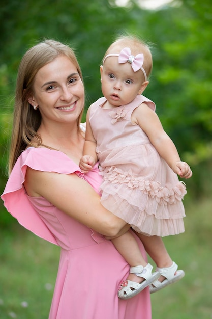 Mulher feliz segura filha de um ano em seus braços Maternidade